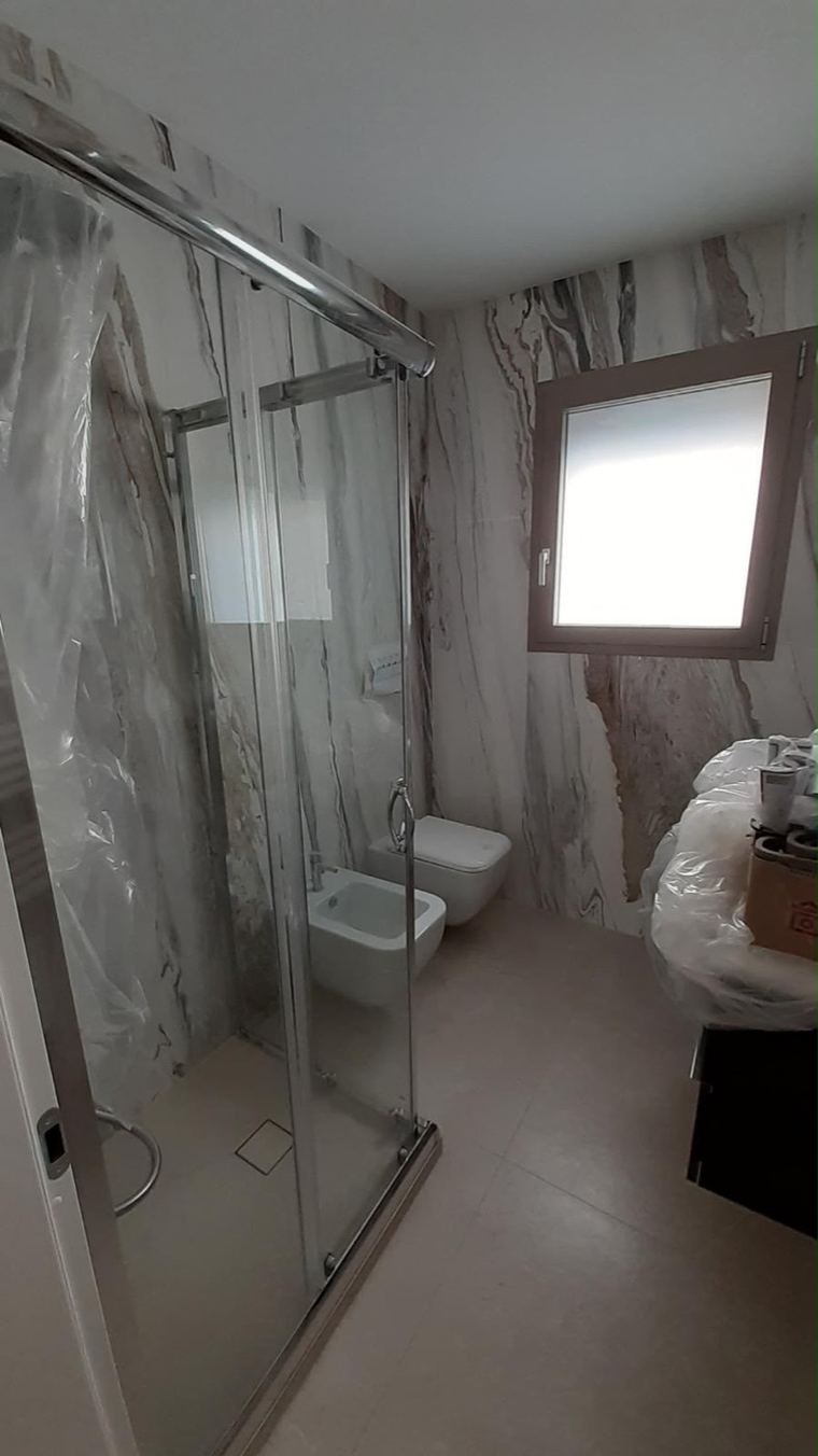 Salle de bain moderne avec douche à l'italienne et murs en marbre