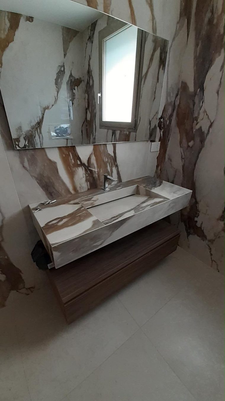 Salle de bain habillée de marbre veiné réalisée par l'équipe carrelage Elyos
