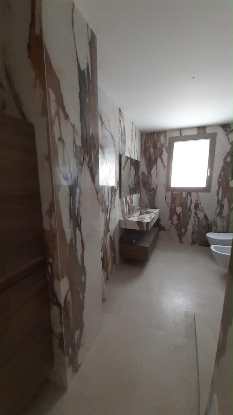 Salle de bain habillée de marbre veiné du sol au plafond