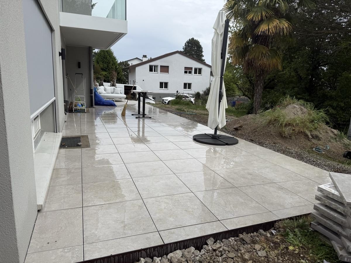 Grande terrasse en grès cérame crème autour d'une villa contemporaine